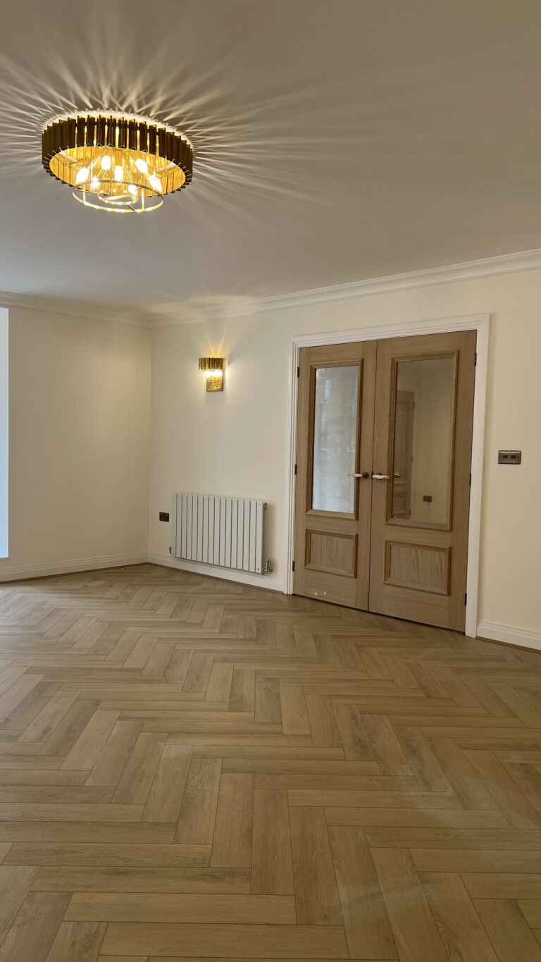 Linen Oak herringbone SPC flooring across a Walsall lounge towards double doors