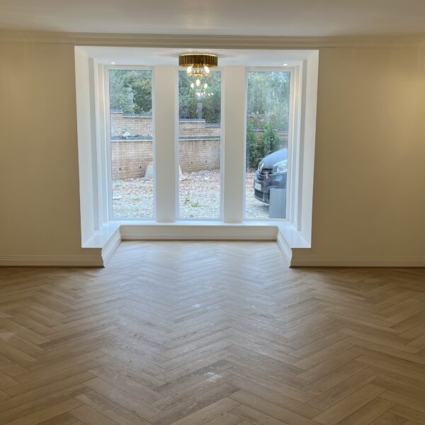 Lignum Core Linen Oak herringbone SPC flooring fitted in a Walsall lounge with a bay window