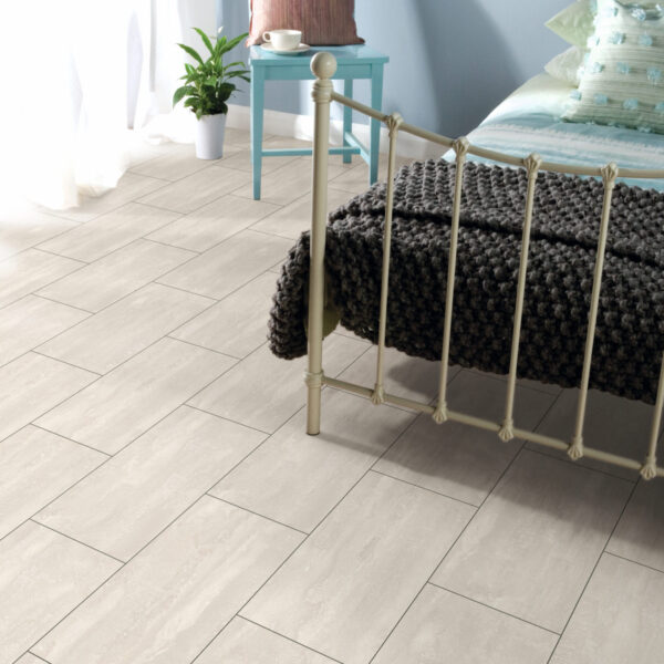 Organic Classic Ice Flow 8mm cream tile-effect laminate flooring in a bedroom